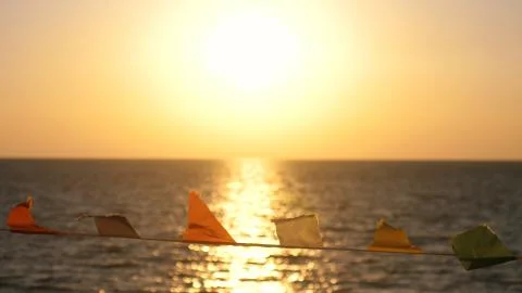 Flags develop in the wind against the background of the sea on the beach during Stock Photos