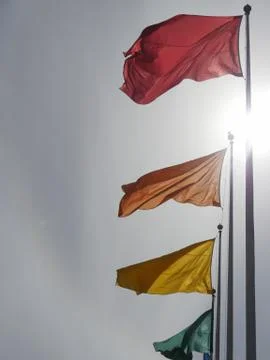 Flags of different colors on flagpoles Stock Photos