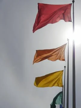 Flags of different colors on flagpoles Stock Photos