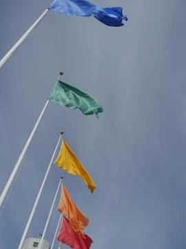 Flags of different colors on flagpoles Stock Photos