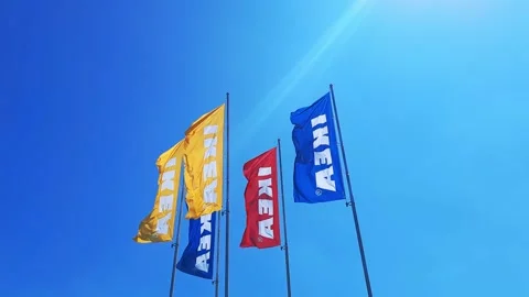 Flags of different colors with word IKEA flutter against sky. Stock Footage 247664195