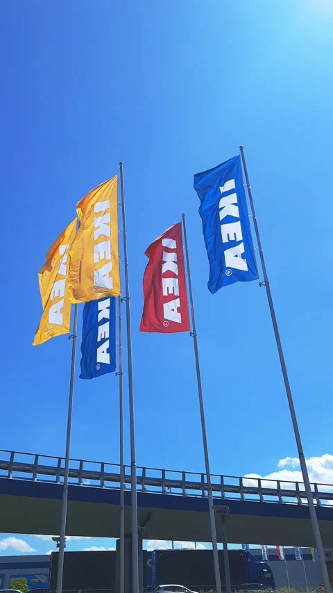 Flags of different colors with word IKEA flutter against sky. Stock Footage 248435057