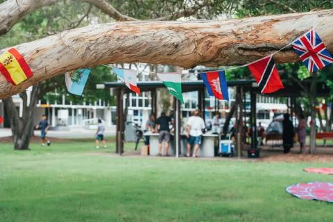 Flags of different countries in the tree branch with blured people in park doing Stock Photos
