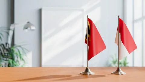 FLAGS OF EAST TIMOR AND MONACO ON TABLE Stock Photos