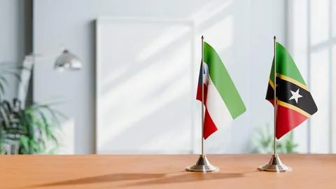 FLAGS OF EQUATORIAL GUINEA AND SAINT KITTS ON TABLE Stock Photos