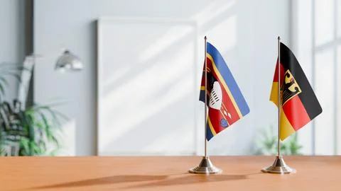 FLAGS OF ESWATINI AND GERMANY ON TABLE Stock Photos
