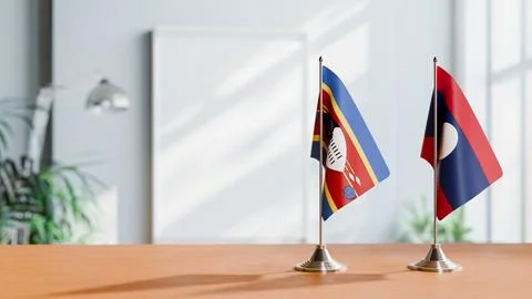 FLAGS OF ESWATINI AND LAOS ON TABLE Stock Photos