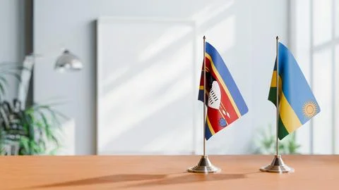 FLAGS OF ESWATINI AND RWANDA ON TABLE Stock Photos