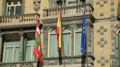 Flags of EU, Spain and Basque country waving on government building facade Stock Footage 87285507