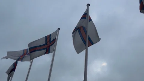 Flags of Faroe islands in row waving in wind with sky and clouds in background Stock Footage 92638419
