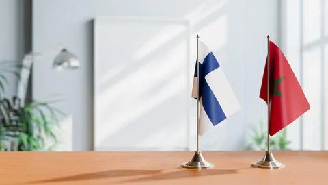 FLAGS OF FINLAND AND MOROCCO ON TABLE Stock Photos