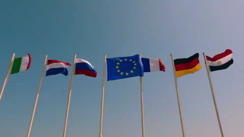 Flags on flagpole of different countries develops on blue sky background, Stock Footage 304002116
