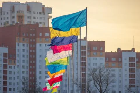 Flags flutter in the wind on a Sunny day against the backdrop of the urban la Stock Photos