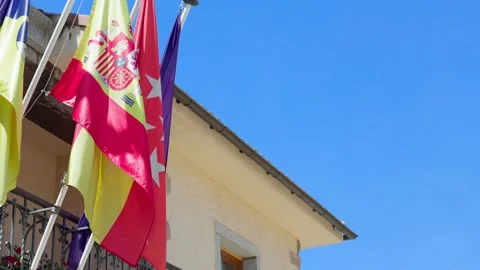 Flags fluttering in a blue sky. The flags are from Europe, Spain and Madrid Stock Footage 313520831