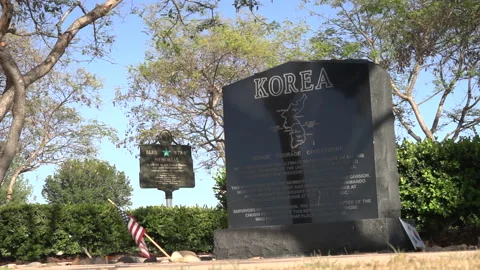 Flags fly at a marker remembering victims of the Korean War Stock Footage 154603571