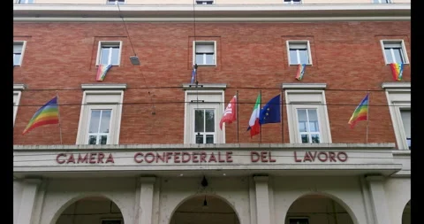 Flags fly from the windows of the Confederal Chamber of Labor. Bologna, Italy Stock Footage 274367286