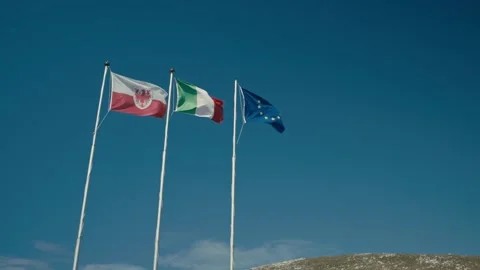 Flags Flying Proudly Against a Clear Blue Sky in a Scenic Mountain Area 库存影片 331169927