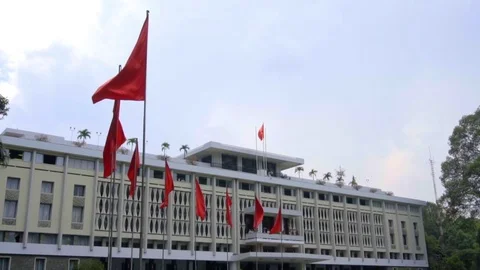 Flags flying in slow motion in front of the Reunification Palace in Ho Chi Minh 스톡 동영상 81414077