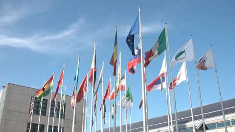 Flags flying united, different flags on blue sky background Stock Footage 134707936