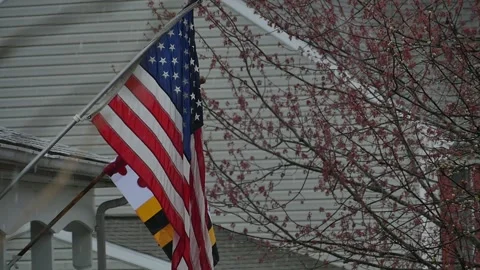 Flags flying on the wall of a house during a rainstorm Stock Footage 152359775