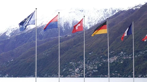 Flags in front of swiss alps and lake Maggiore Stock Footage 127862175