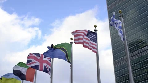 Flags in front of United Nations in NYC. USA, UK and Tanzania flags flying Stock Footage 176108181