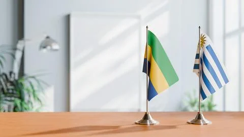 FLAGS OF GABON AND URUGUAY ON TABLE Stock Photos