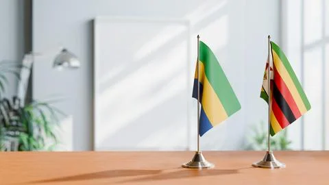 FLAGS OF GABON AND ZIMBABWE ON TABLE Stock Photos