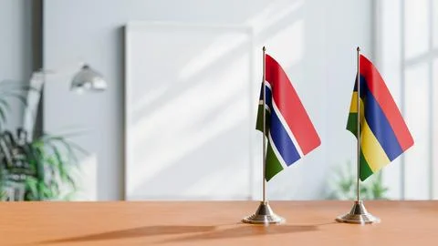 FLAGS OF GAMBIA AND MAURITIUS ON TABLE Stock Photos