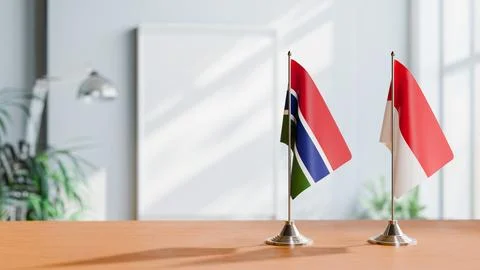 FLAGS OF GAMBIA AND MONACO ON TABLE Stock Photos