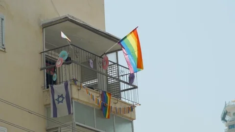 Flags of Gay Pride are set on a balcony in Tel Aviv, Israel during Pride month Stock Footage 110654926