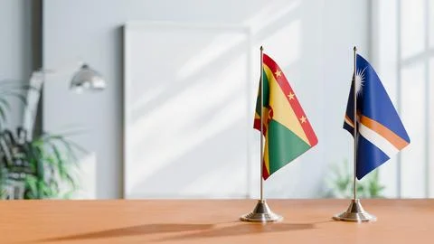FLAGS OF GRENADA AND MARSHALL ISLANDS ON TABLE Stock Photos