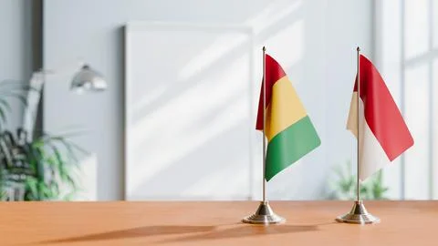 FLAGS OF GUINEA And INDONESIA ON TABLE Stock Photos