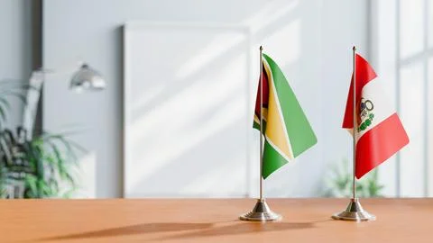 FLAGS OF GUYANA And PERU ON TABLE Stock Photos