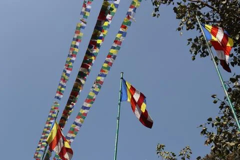Flags hang on string line and pole on bright blue sky background Stock Photos