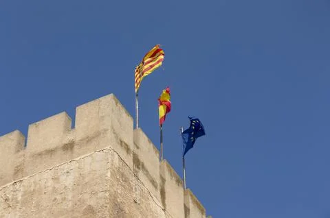 Flags hoisted over the towering stone tower Stock Photos