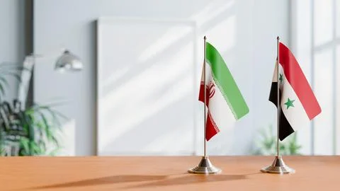 FLAGS OF IRAN AND SYRIA ON TABLE Stock Photos