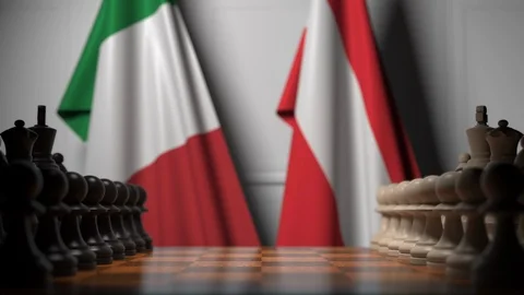 Flags of Italy and Austria behind pawns on the chessboard. Chess game or Stock Footage 116600564