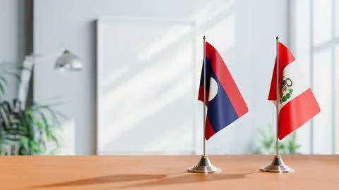 FLAGS OF LAOS AND PERU ON TABLE Stock Photos