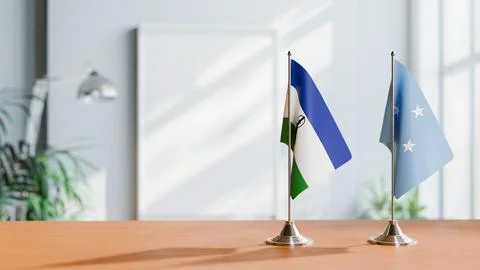 FLAGS OF LESOTHO AND MICRONESIA ON TABLE Stock Photos