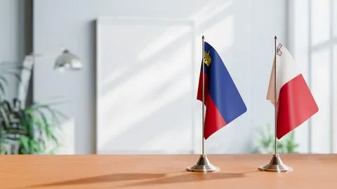 FLAGS OF LIECHTENSTEIN AND MALTA ON TABLE Stock Photos