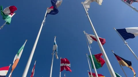 Flags of many countries waveing in the wind with blue sky from below Stock Footage 274935515