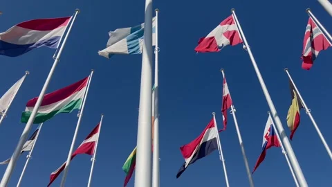 Flags of many countries waveing in the wind with blue sky from below Stock Footage 274935562