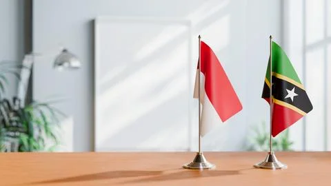 FLAGS OF MONACO AND SAINT KITTS ON TABLE Stock Photos