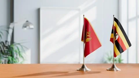FLAGS OF MONTENEGRO AND UGANDA ON TABLE Stock Photos