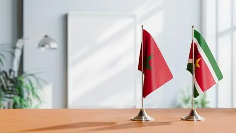 FLAGS OF MOROCCO AND SURINAME ON TABLE Stock Photos