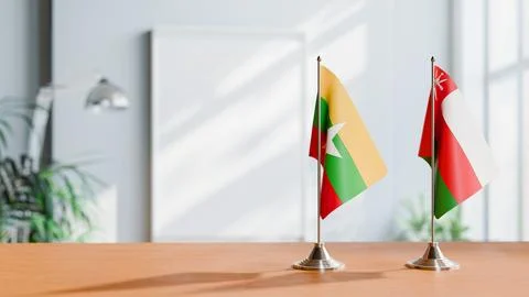 FLAGS OF MYANMAR AND OMAN ON TABLE Stock Photos