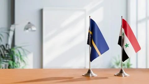 FLAGS OF NAURU AND SYRIA ON TABLE Stock Photos