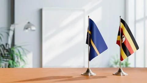 FLAGS OF NAURU AND UGANDA ON TABLE Stock Photos