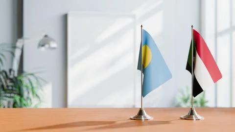 FLAGS OF PALAU AND SUDAN ON TABLE Stock Photos